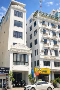 a car parked in front of a white building at Ngọc Tùng Hotel in Ha Long +34 photos