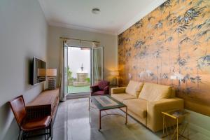 a living room with a couch and a tv at Apartamentos Abreu Suites in Seville