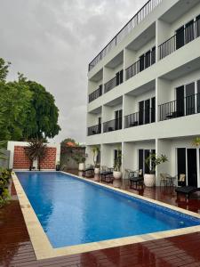 a swimming pool in front of a building at Griya Pastoral in Denpasar