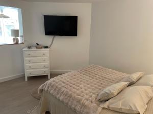 a bedroom with a bed and a tv on the wall at À la clef des champs in Chauray