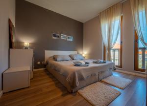 a bedroom with a bed and a large window at Къща за гости В 12 и 5 in Dolna Banya