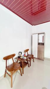 a room with three wooden tables and a kitchen at Mars Homestay Ubud in Ubud