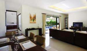 a living room with a dining table and a couch at Villa Lombok by Holiplanet in Rawai Beach