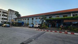 a street with cars parked in front of a building at Blueplace บลูเพลส in Ban Talat Rangsit