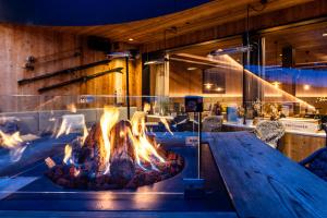 a fire pit in the middle of a restaurant at Hotel Hell in Ortisei