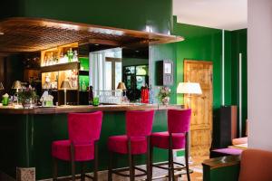 a bar with red chairs in a green room at La Posta Hotel & Thermal Spa - Adults Only in Bagno Vignoni +67 photos