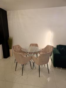 a glass table and two chairs in a living room at Perła Residence in Kutno