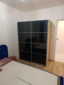 a bedroom with a large black cabinet with glass doors at Perła Residence in Kutno