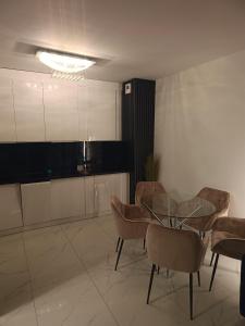 a dining room with a glass table and chairs at Perła Residence in Kutno