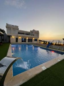 a large swimming pool in front of a building at Magic View ماجيك فيو in Al Salt