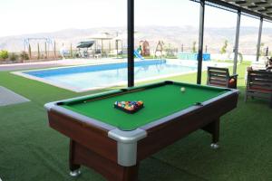 a pool table in front of a swimming pool at Magic View ماجيك فيو in Al Salt