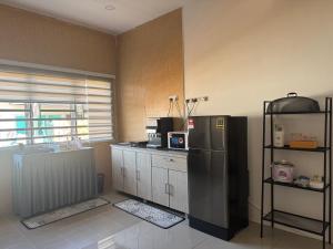 a kitchen with a stainless steel refrigerator in a room at Harees Homestay in Kuala Lipis