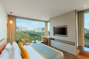 a hotel room with a bed and a large window at Plume Hotels, India Expo Mart, Greater Noida in Greater Noida