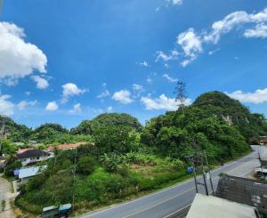 an empty road in a village with trees at Saan Stay in Ban Krabi Yai