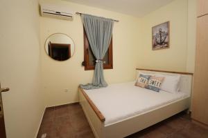 a small bedroom with a bed and a window at Golden Beach, Gerakini in Gerakini