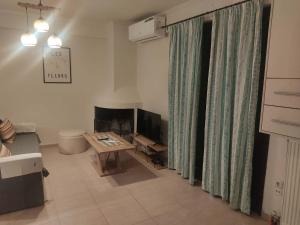 a living room with a table and a fireplace at Super central studio apartment in Kalavrita
