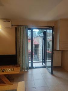 a living room with a sliding glass door to a patio at Super central studio apartment in Kalavrita