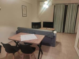 a living room with a couch and a table with chairs at Super central studio apartment in Kalavrita