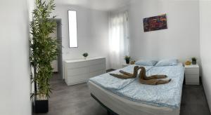 a bedroom with a bed with a wooden animal on it at Pandora apartment in Las Galletas +11 photos