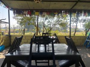 a wooden table with chairs in front of a window at Hostel Jungle Beats in Sauraha