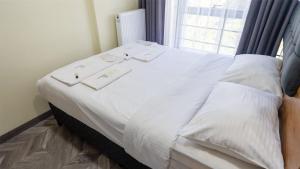 a bed with white sheets in a room with a window at Elegance Sirius in Kayseri +3 photos