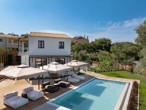 a villa with a swimming pool and umbrellas at CorfuVille Luxury Villas in Danilia