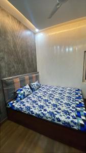 a bedroom with a bed with blue sheets and pillows at Shree residences in Vrindāvan