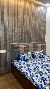 a bedroom with a bed with blue and white sheets at Shree residences in Vrindāvan