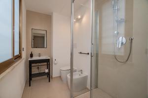 a bathroom with a shower and a toilet and a sink at Domo Le Mura Puniche, nel cuore di Olbia in Olbia
