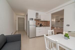 a kitchen and living room with a table and a refrigerator at Domo Le Mura Puniche, nel cuore di Olbia in Olbia