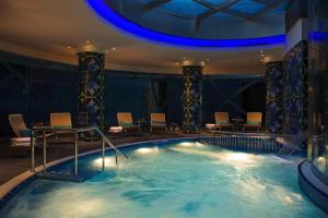 a large pool in a hotel with chairs and a table at Renaissance Izmir Hotel in İzmir