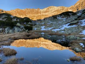 a reflection of a mountain in a pool of water at La Bubu in Uricani