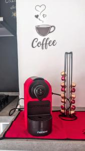 a red coffee machine sitting on top of a red table at Casina del Sole - Rho Fiera Milano in Bollate