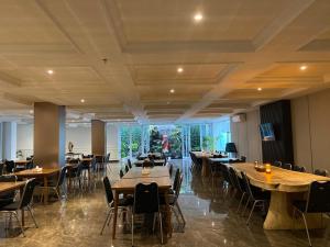 a dining room with wooden tables and chairs at Griya Pastoral in Denpasar