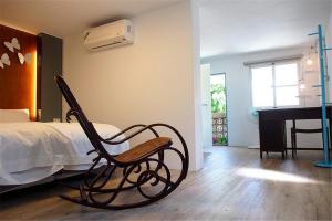 a chair in a bedroom with a bed and a piano at Chung Fu Inn in Tainan