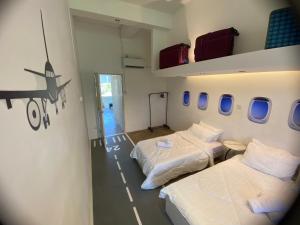 two beds in a room with an airplane on the wall at AeroHomesuites Tawau in Tawau