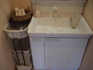 a bathroom with a sink and a basket next to it at ゲストハウス有無 in Mihama +57 photos