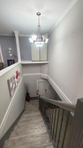 a hallway with a staircase with a chandelier at J & J Dream Villa Ltd in Abbotsford +42 photos