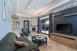 a living room with a green couch and a flat screen tv at Villa Elvin in Kalkan