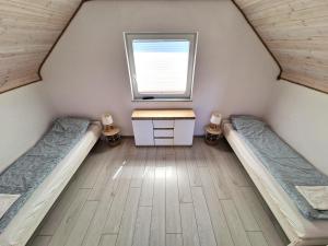 a room with two beds and a desk and a window at Domki Rajski Wypoczynek z basenem in Jastrzębia Góra +13 photos