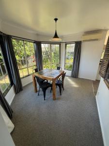 a dining room with a wooden table and chairs at City centred living! in Palmerston North