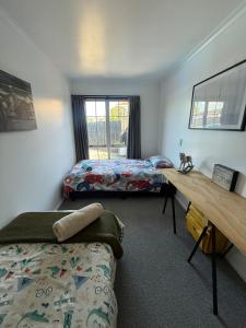 a bedroom with two beds and a desk with a cat on it at City centred living! in Palmerston North