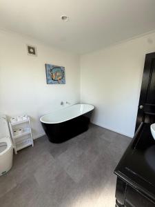 a bathroom with a black and white bath tub at City centred living! in Palmerston North +20 photos