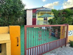 a gate in front of a house with an umbrella at Sucasa Apartment in Willemstad