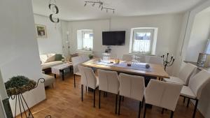 a dining room and living room with a table and chairs at Ferienhaus check ferien dot world in Berenbach