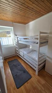 a room with two bunk beds with a rug at Ferienhaus check ferien dot world in Berenbach