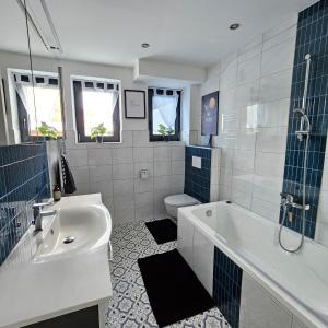 a bathroom with a tub and a sink and a toilet at Alp Haus Grossglockner in Bruck an der Großglocknerstraße +53 photos