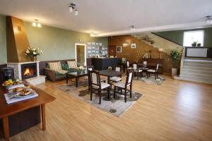 a living room with a fireplace and a table and chairs at Комплекс Кремена in Kremena
