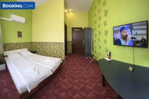 a bedroom with a bed and a tv on the wall at Комплекс Кремена in Kremena