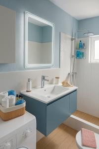 a blue bathroom with a sink and a mirror at Colorful House Tsoutsouras in Tsoutsouros +59 photos